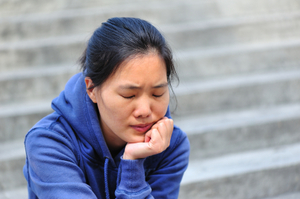 stressed woman sitting with chin in hand