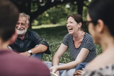 group of people laughing in a park