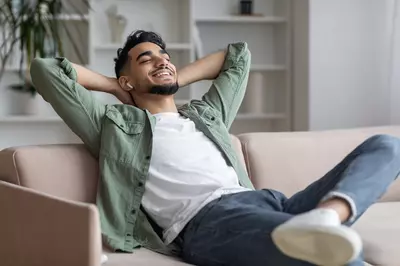 man relaxing on the couch with airpods