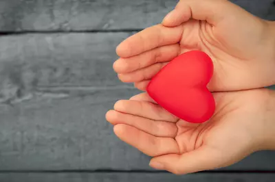 hands holding a fabric red heart