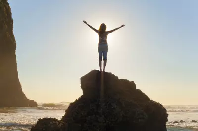 silhouette of a person at the beach arms outstretched