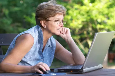 middle aged woman using laptop outside