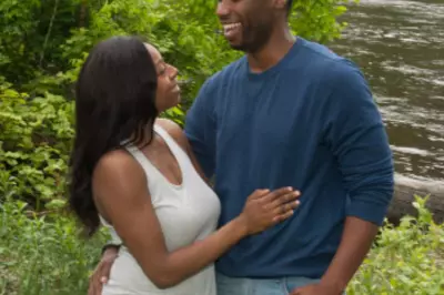 a couple looking happily at one another in the forest