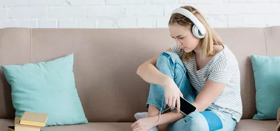 girl sitting on couch listening to music