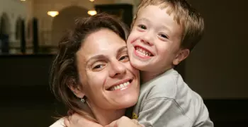 Woman smiles as she hugs her small child