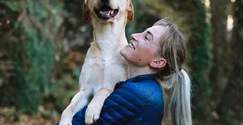 Blond woman holding blond dog