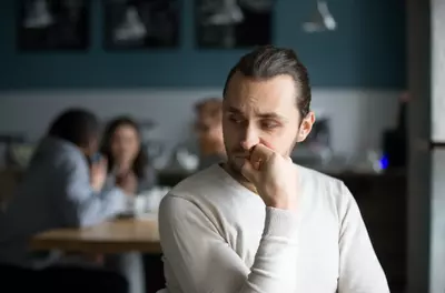 lonely man looking uncertain in cafe