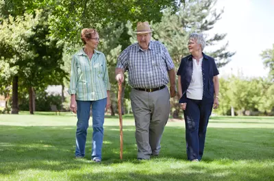 three people walking in a grassy area