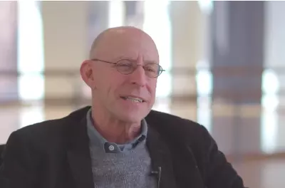 Still of Michael Pollan speaking to the camera in front of a light background