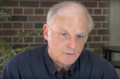 Richard Louv speaking in front of a brick background