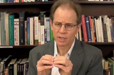 Dan Siegel, sitting in front of a bookshelf