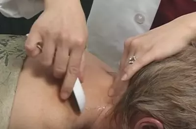 close up of hands spreading oil on a woman's neck