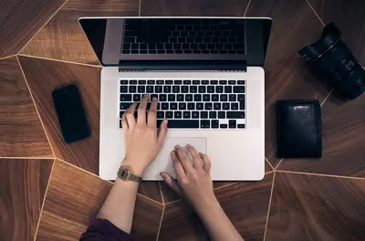 hands typing on a laptop keyboard