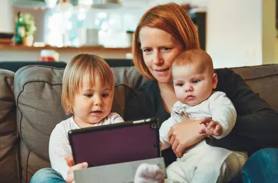 mother and two young children sitting on couch