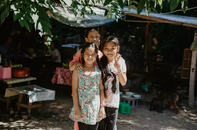 Three young girls smiling with their arms around each other