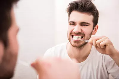 man brushing teeth