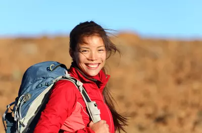 Young female sitting relaxed during her hike. Fitness woman resting after  trekking stock photo