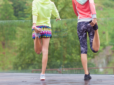 two friends stretching together before working out